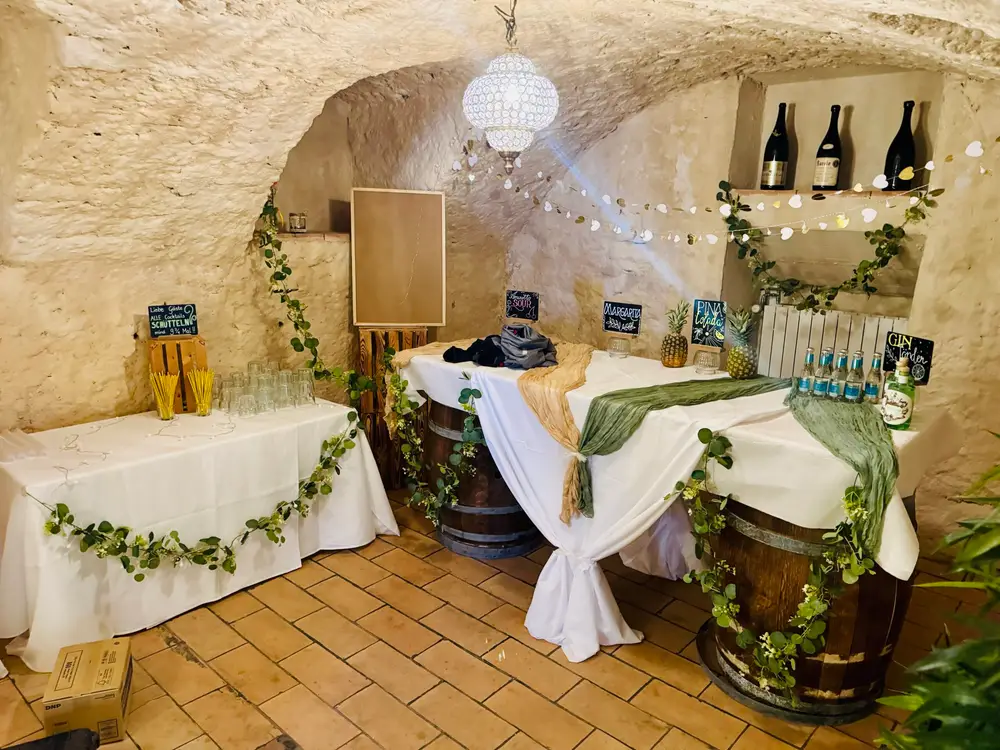 Bar im Gewölbekeller des Mühlerama Seon aus Holzfässern mit Grüngirlande und Stehtischen