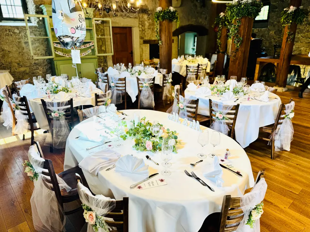 Festlich gedeckte runde Tische mit Blumenschmuck im Mühleraum des Mühlerama Seon